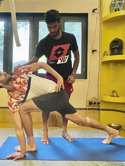 Another angle of a hands-on adjustment in a side lunge. The focus here is on grounding the back foot and extending through the spine to create maximum length and space.
