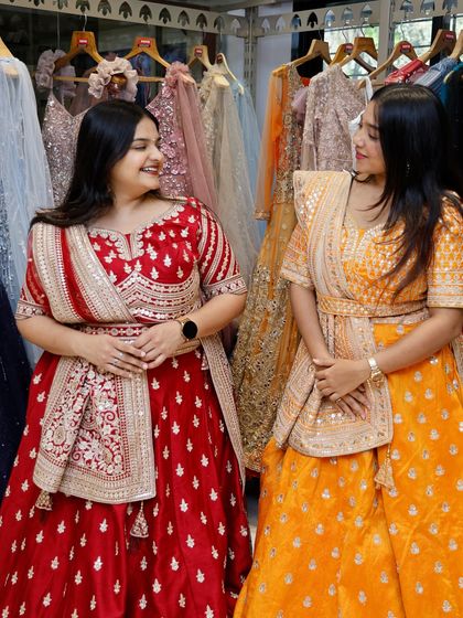 Bold, bright, and beautiful. Two friends twinning in red and yellow lehengas, a perfect look for a Haldi ceremony or wedding.