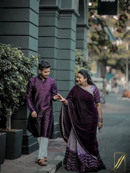Capturing a candid moment as the couple walks down a classic Mumbai street. The architecture of the Kala Ghoda area provides a sophisticated urban backdrop for their traditional yet stylish outfits.