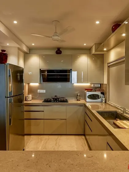Another angle of the C-shaped acrylic kitchen, showing the ample counter space and integrated appliances.