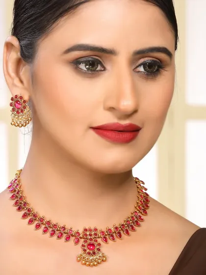 This image highlights a traditional ruby necklace set against a dark saree, making the colors pop. The model's confident pose makes this a strong image for advertising and lookbooks.
