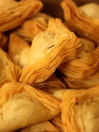 A close up of our signature warkhi samosas. The delicate, flaky pastry is a family specialty, and we offer them with mutton, chicken, or vegetable fillings for any occasion.