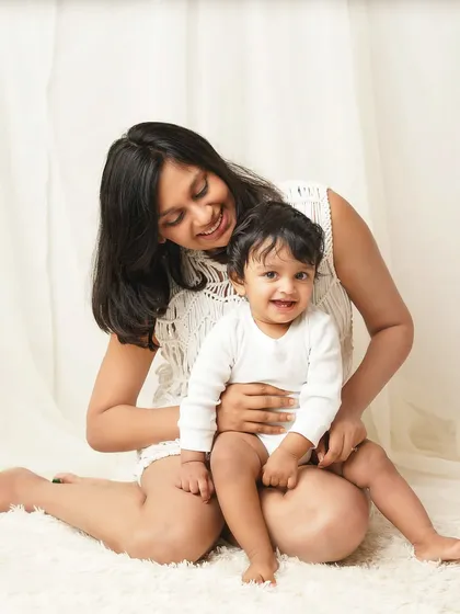 A mother looks down lovingly at her smiling son. The soft lighting and gentle interaction create a warm and tender mother-son portrait.