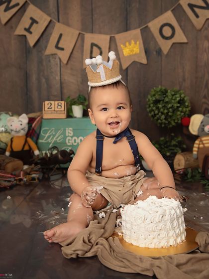 A wild one is turning one. This adorable little explorer is enjoying his cake smash in our rustic, woodland-themed setup, complete with a cute crown.