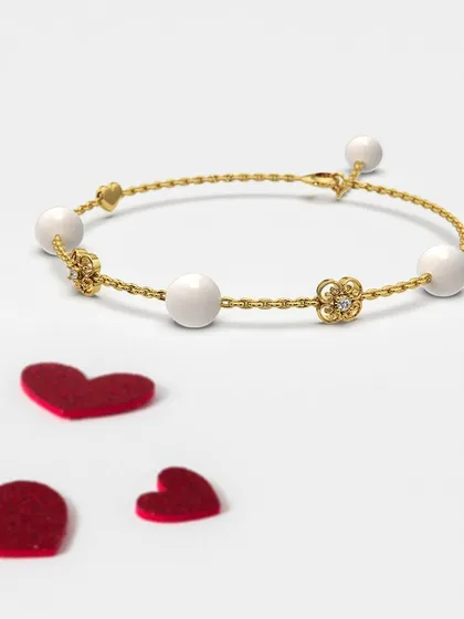 Another view of the pearl charm bracelet, this time showing the intricate floral accents alongside the heart. It is a piece designed to let your love shine as bright as your affection.