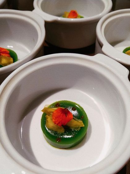 A unique and savory-leaning dessert: Moringa custard with drumstick marrow, garnished with an edible flower.