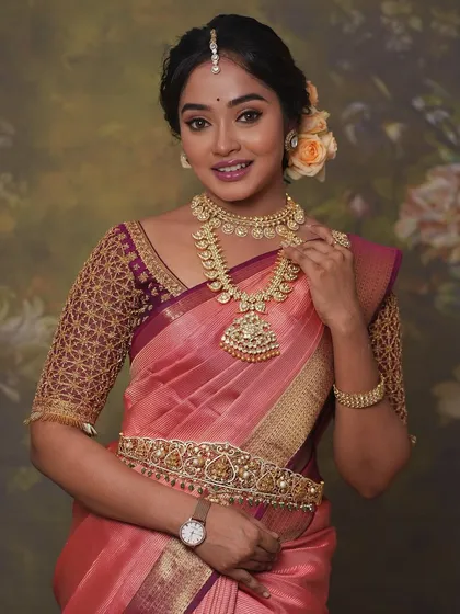 A beautiful studio portrait of actress Sowmya John, wearing the peach Kanchivaram and custom maroon blouse with gold jaal embroidery.