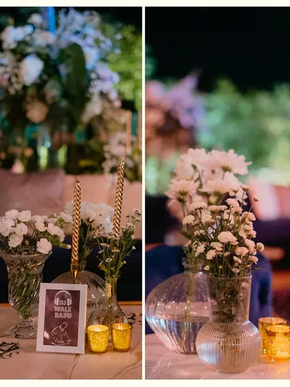 A collage of table details from a Sangeet, featuring quirky framed signs, simple floral arrangements in glass vases, and the warm glow of golden votives.