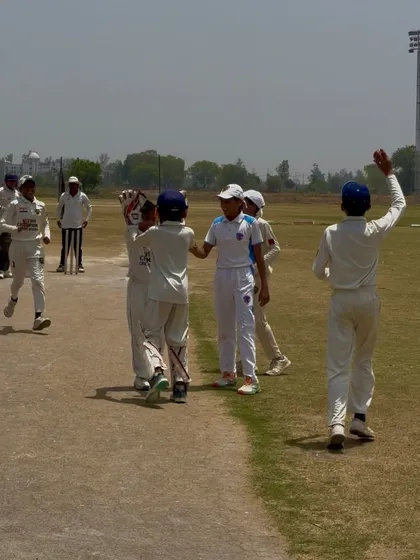 The team congratulating the bowler after taking a wicket.