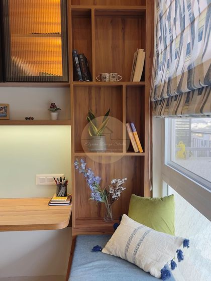 A close-up of the study area, showing the open wooden bookshelf and the window seat, creating a perfect corner for work or reading.