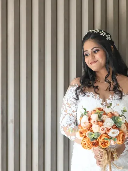 An elegant bridal portrait against a modern, textured wall. The simple background makes the bride and her beautiful bouquet stand out.