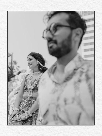 A black and white portrait that captures the essence of a Haldi ceremony. The focus is on the couple's expressions and the textures of the event, creating a timeless and artistic feel.