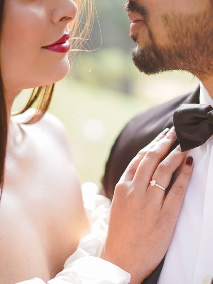 A detailed close-up shot focusing on the bride's hand on her partner's tuxedo, highlighting the engagement ring. It’s these small, significant details that I love to capture.