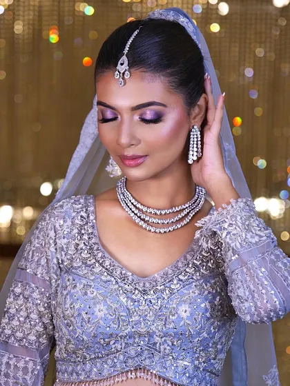 A touch of glam, a dash of love. This close-up shows the beautiful purple and silver eyeshadow, perfectly blended for a modern bridal look.