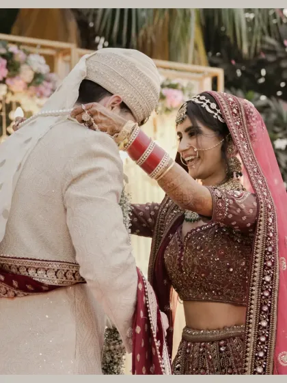 A joyful moment during the varmala exchange, the bride's smile is infectious as she garlands the groom.
