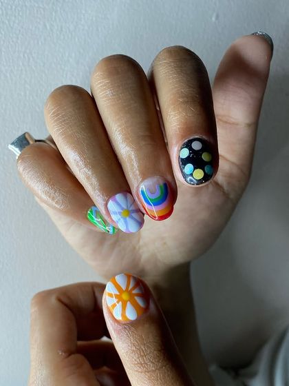 A creative and colorful design with a rainbow, a 3D flower, and polka dots, perfect for someone who loves unique nail art.