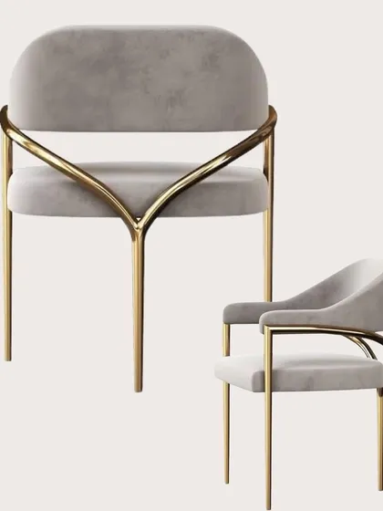 A showcase of our custom dining chair, featuring a V-shaped gold metal frame and plush grey velvet upholstery. This piece is designed to be both a comfortable seat and a sculptural object.