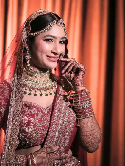 This bride's playful pose shows off her royal elegance. The makeup is a perfect blend of tradition and luxury, with a focus on a flawless, glowing complexion.