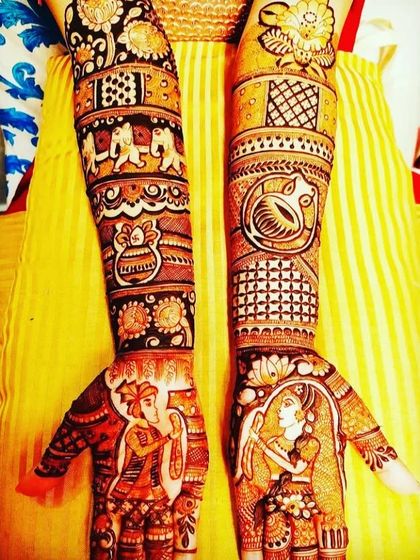 A classic design with the couple in a varmala pose. The arms are filled with traditional motifs like elephants, kalash, and floral patterns.