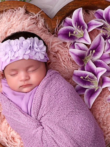 Sweet dreams. This little one is sleeping peacefully in a heart-shaped bowl, surrounded by purple lilies.