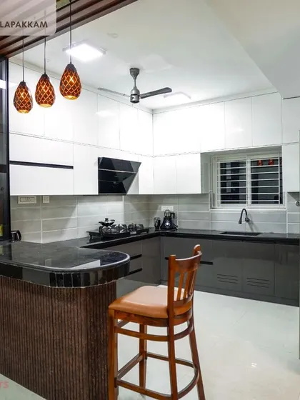 This kitchen combines classic grey and white tones with a functional breakfast bar. It’s a perfect example of how we design open-concept living spaces, creating a central hub for the family to gather. The design includes a mix of open and closed storage for both style and utility.