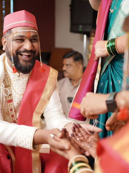 A candid moment of laughter and joy during the wedding rituals, showing the groom's happiness.