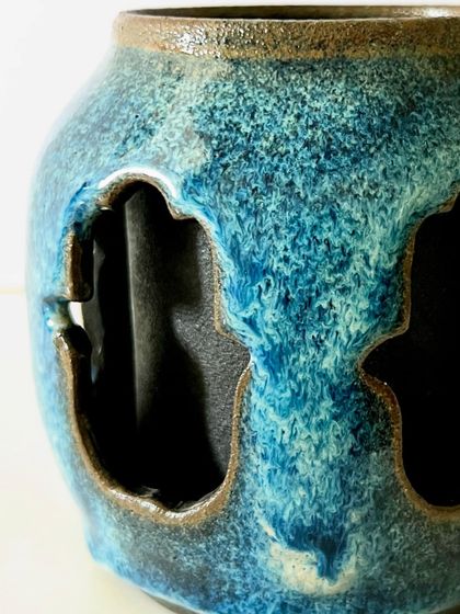 A close-up detail of the reactive blue glaze on the Hamsa mug. I love how the glaze breaks over the edges of the carving, highlighting the texture and creating unique patterns.
