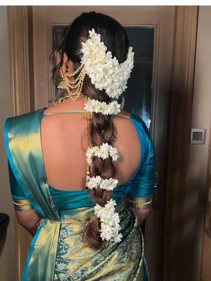 Another view of the jasmine-adorned South Indian braid. This angle highlights the delicate side chains and the neatness of the braid, essential for a polished bridal look.