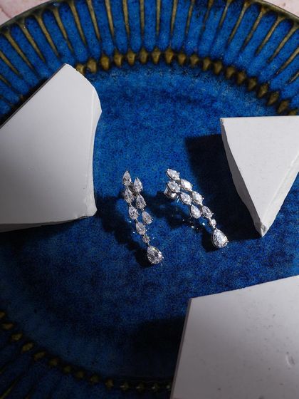 A striking contrast of sharp, brilliant diamonds against broken plaster pieces on a vibrant blue plate. This composition is all about modern art meeting classic elegance.