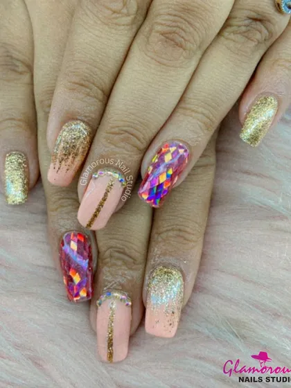 A fun, "party on your nails" look. This set combines a peachy nude base with gold glitter, gold-lined accents, and a stunning, iridescent shattered glass effect on the accent nails.