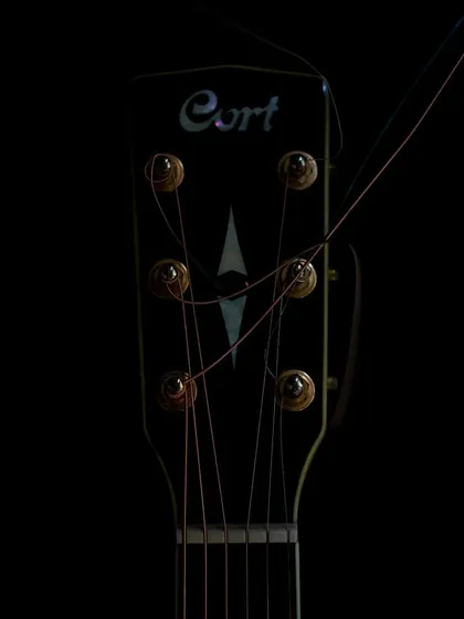 The headstock of my Cort guitar during a string change. It's a bit of a messy process, but worth it for the sound.