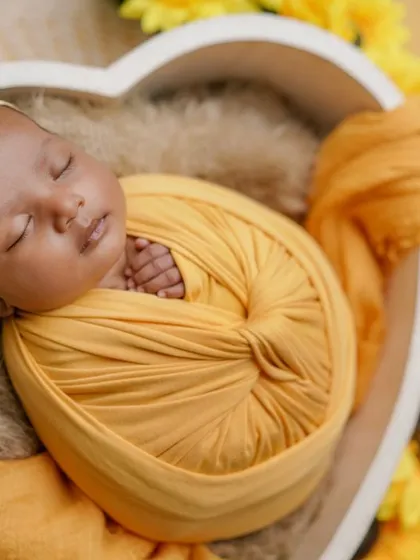 A heart full of sunshine. I love using bright, cheerful colors to reflect the happiness a new baby brings. This little one is nestled in a heart, surrounded by sunny yellow flowers.