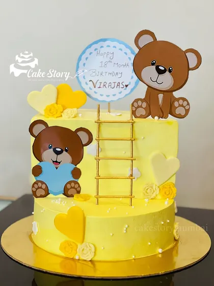Celebrating a special 18-month birthday with this adorable teddy bear cake. The cheerful yellow design is decorated with cute bears, hearts, and a little ladder.