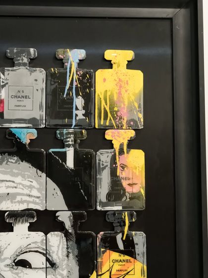 Detail of the "Dali In A Bottle" artwork, showing the dripping paint and pop art fragments contained within the sculpted Chanel bottles.