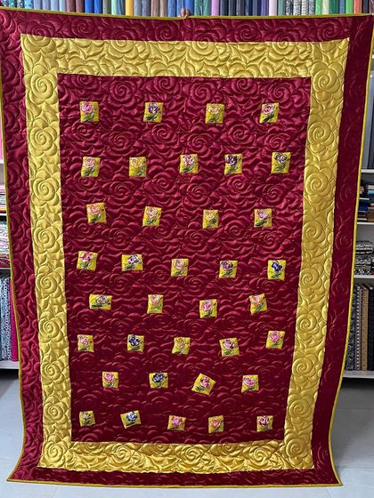 A full view of the red and gold silk quilt, showing how the quilting adds a sense of opulence.