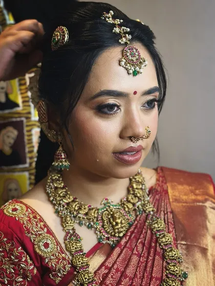 A candid moment of the bride, her makeup looking fresh and her expression joyful.