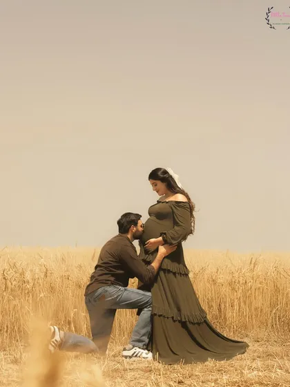 A classic maternity pose with Hasan Sartaj kissing Shireen's baby bump, a timeless expression of love and anticipation.