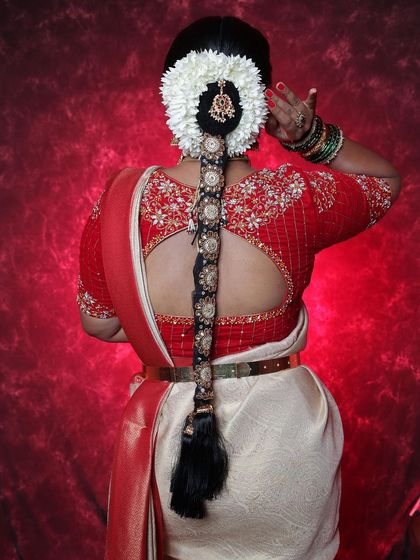 An ornate bridal braid featuring intricate black and gold hair accessories. This style is perfect for a bride who wants a traditional look with a touch of unique detailing.