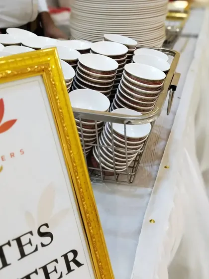 Neatly stacked bowls and plates ready for service. We use high-quality, clean, and elegant crockery for all our events.