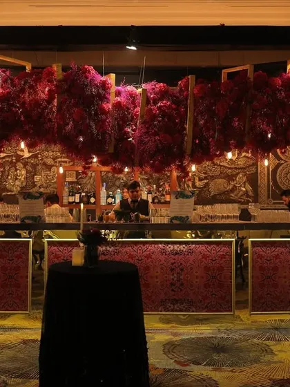 We elevated the bar at this Sangeet with a canopy of heavy pink and red florals. The design, combined with a traditional carved backdrop, created a regal and romantic atmosphere.