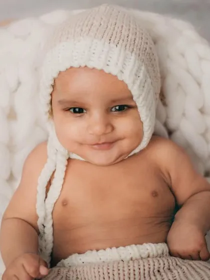 A happy, smiling baby is the best thing in the world. This little guy clearly enjoyed his cozy and warm photoshoot.