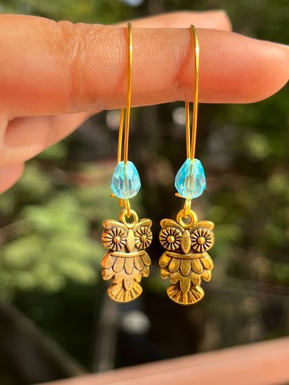 A cute pair of gold-tone owl charm earrings with a light blue crystal bead. These are another great option from my affordable daily wear collection.