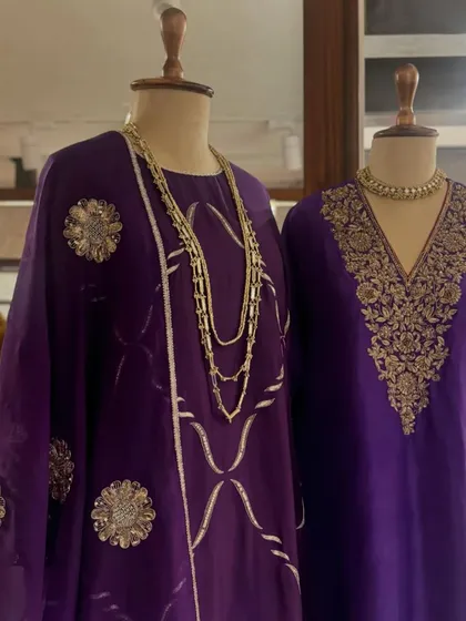 A display of regal purple kaftans, each featuring unique gold embroidery, from floral motifs to geometric patterns.