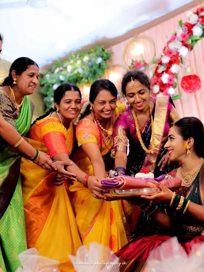 A heartwarming, candid moment as family members gather around the bride during a traditional engagement ritual.