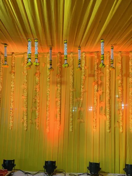 A close-up of the hanging floral garlands used in the Haldi backdrop. The combination of yellow marigolds and white tuberoses is a classic choice for Indian pre-wedding ceremonies.