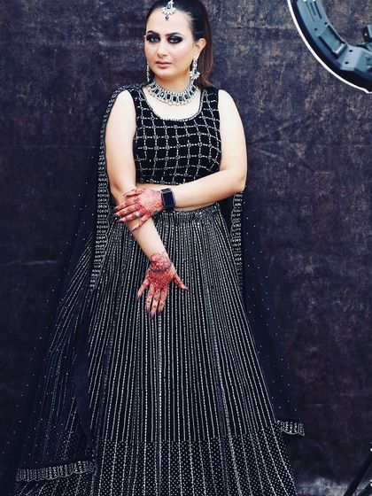 A modern black lehenga featuring a checkered pattern blouse and a striped sequin skirt. This rental is for someone who loves bold, graphic patterns.