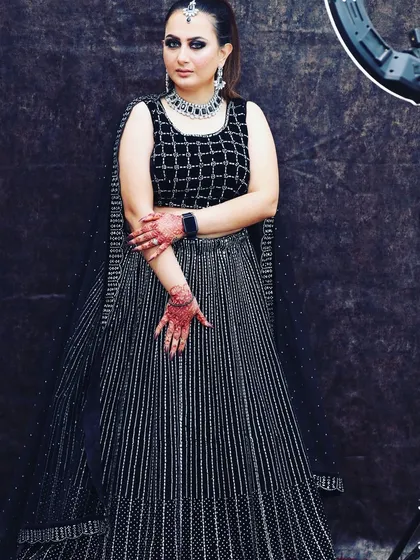A modern black lehenga featuring a checkered pattern blouse and a striped sequin skirt. This rental is for someone who loves bold, graphic patterns.