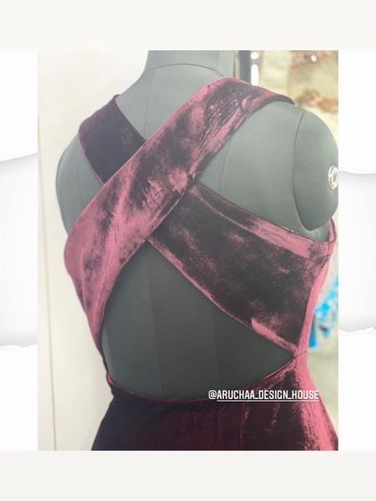 A bold statement with this wine-colored velvet blouse featuring a modern criss-cross back design.