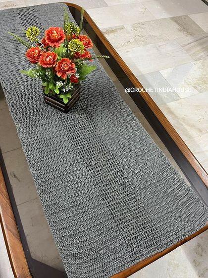 This simple and modern grey crochet table runner is perfect for a dining or console table. Its minimalist design and neutral color fit well with many different decor styles.