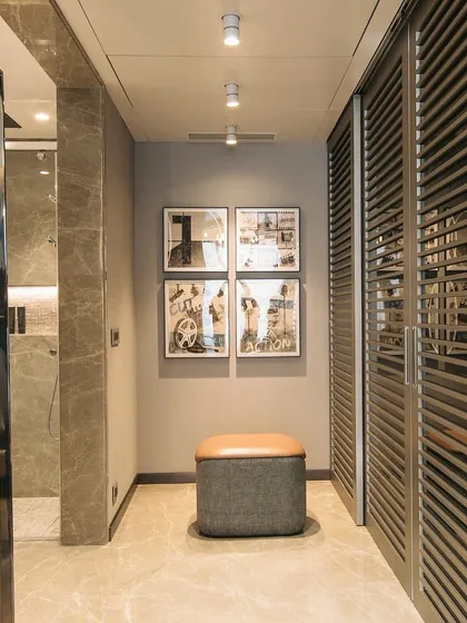 We believe in making complicated things simple. Here, we combined the dressing area with the dry part of the bathroom, adding space and glamour to both. The louvered wardrobe doors add texture and visual interest while ensuring ventilation.